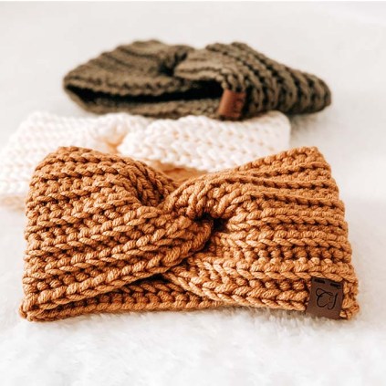An image with three crochet headbands, one in burnt yellow, one cream and one in olive green.