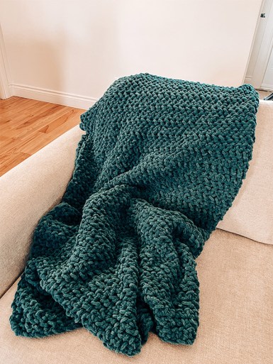 A picture of a blue crochet blanket on a couch